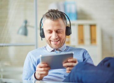 Mężczyzna słucha na słuchawkach główne style muzyki rozrywkowej.